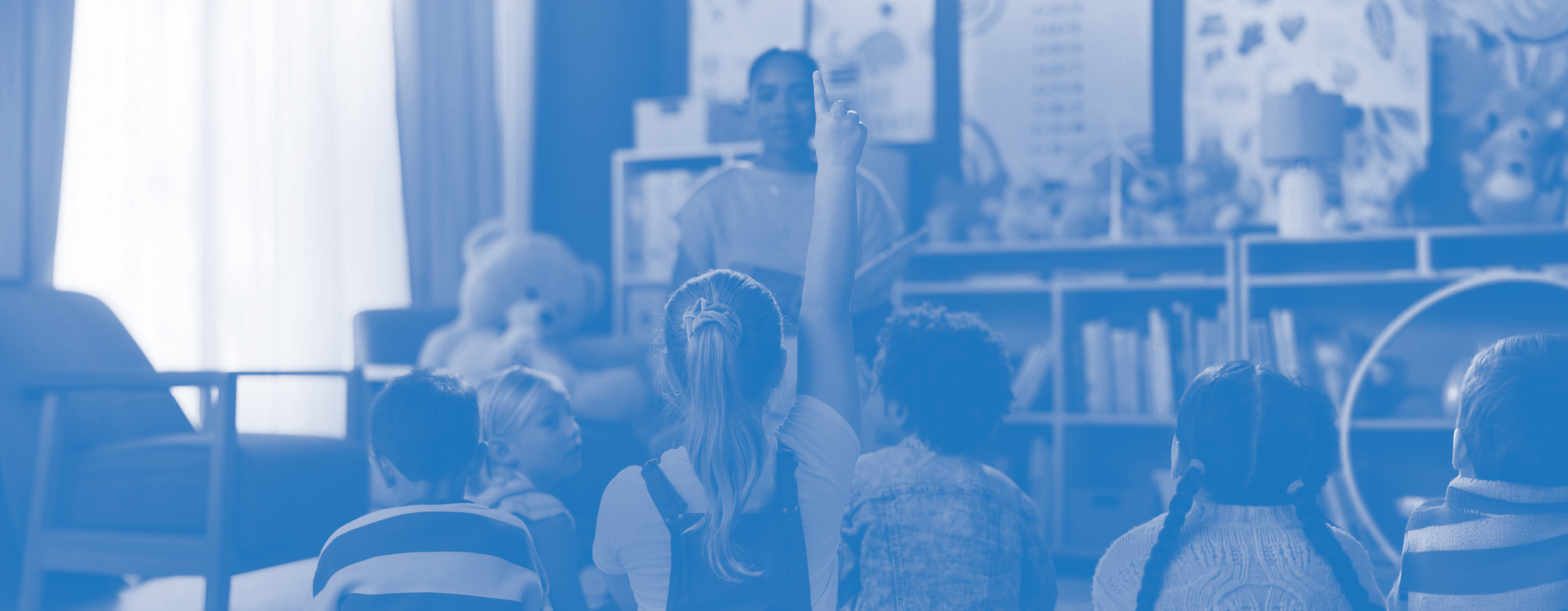 child raising hand in classroom